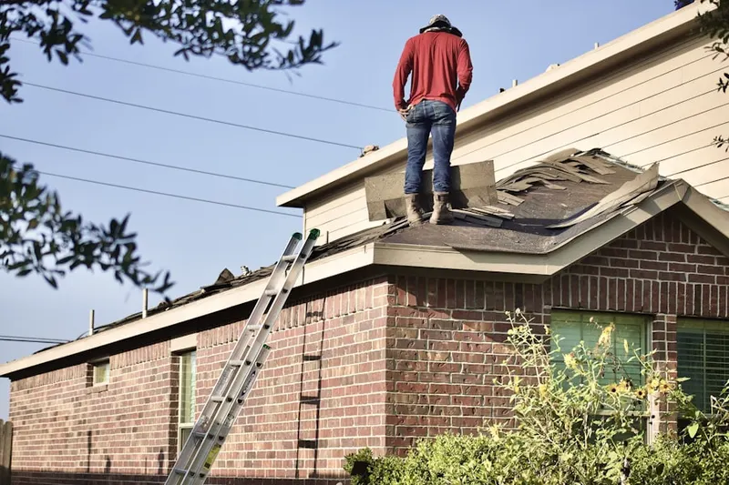 Professional roofer working on a residential roof in Mravlag Manor